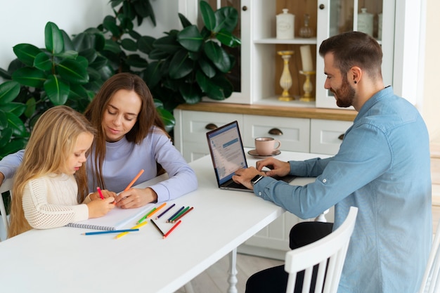A parent sitting at a desk with their child, reviewing the child's standardized test results on a tablet. The parent is pointing at a specific section of the results, and the child looks engaged and curious.