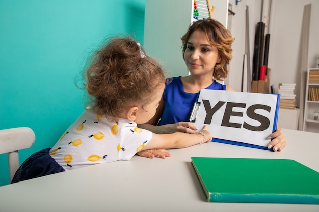 A teacher working with a student who has a visual impairment, providing accommodations during a standardized test. The student is using a screen reader, and the teacher is offering guidance and support.