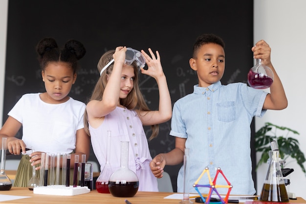 A group of elementary school students in a charter school science class, conducting an experiment with enthusiasm, highlighting the hands-on learning approach often found in these schools.