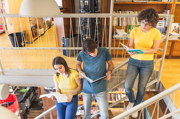 A photo of teachers collaborating in a school hallway, with students visible in the background, representing the importance of programs that support educator development.