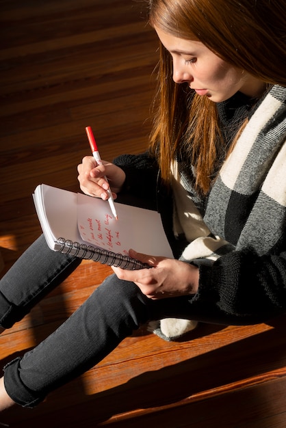 A student is using a planner to schedule their study time, including specific slots for social media breaks. The scene emphasizes time management and the importance of balancing academic work with social activities.