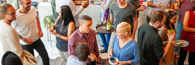 A person attending a professional networking event, engaging in conversations with other attendees. The scene is vibrant and bustling, with people exchanging business cards and ideas.
