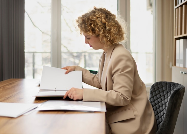 A person sitting at a desk reviewing financial documents and using a calculator, representing the active management of personal finances.