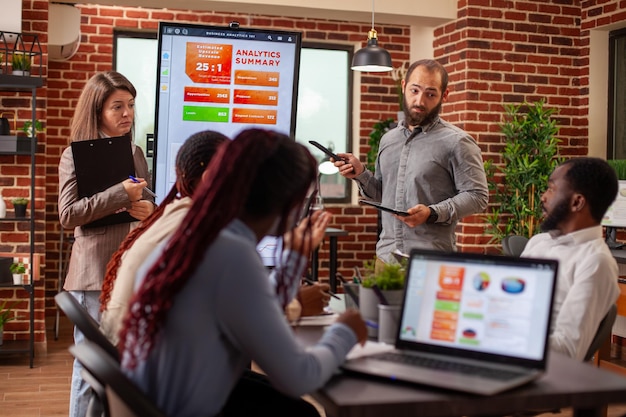 A workshop scene showcasing a diverse group of entrepreneurs participating in a training session on digital marketing strategies, with a presenter at the front and engaged participants taking notes.