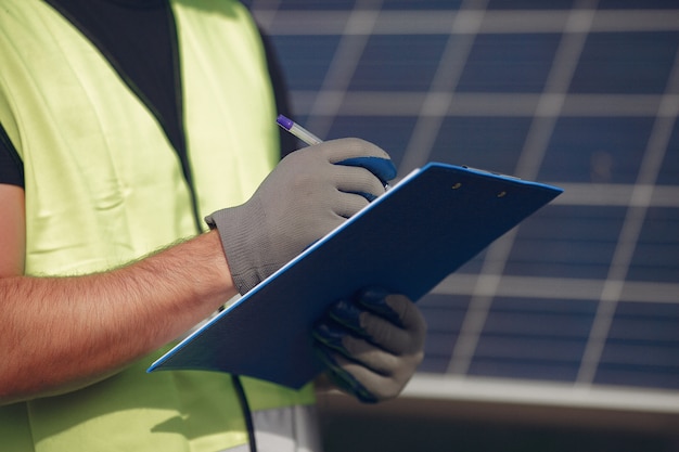 A close-up shot of a technician working on a complex solar panel array, wearing protective gear, with focus on the advanced technology.