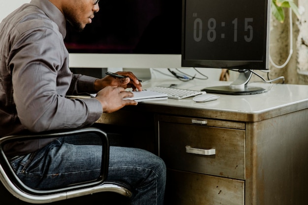 An image of a person confidently sitting in front of a computer, researching salary data on various websites. The scene is well-lit, and the person is focused and engaged, with charts and graphs visible on the screen. The surrounding environment is tidy and professional, conveying a sense of preparation and knowledge gathering