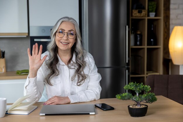 A person conducting a virtual informational interview, smiling and engaged in a video call. The background is a well-lit home office, suggesting a comfortable and professional setting.