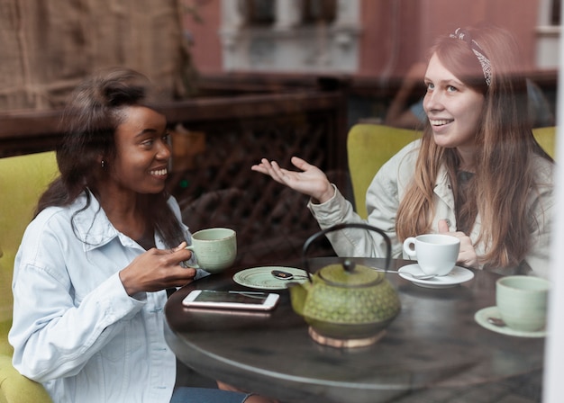 Two professionals, a mentor and mentee, sitting in a coffee shop, having an engaging discussion with open body language, symbolizing trust, connection, and meaningful guidance.