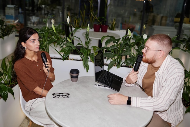 Two people engaged in a mock interview, with one person acting as the interviewer and the other as the interviewee, in a modern office setting.