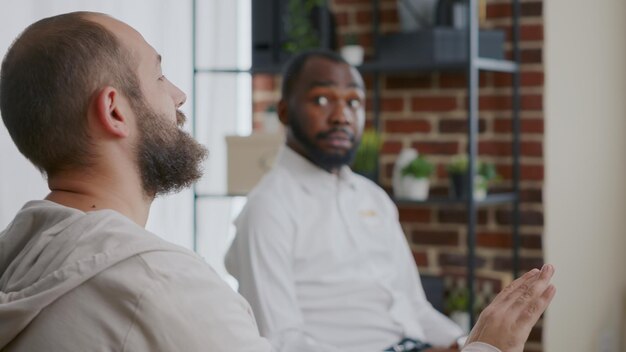 A diverse panel of interviewers is listening attentively to a candidate who is passionately answering a question. The setting is a modern office with natural light.