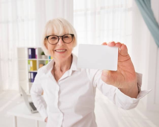 A close-up of a Medicare card in a senior's hand, with a doctor's office blurred in the background. The focus is on the card and the hand holding it.