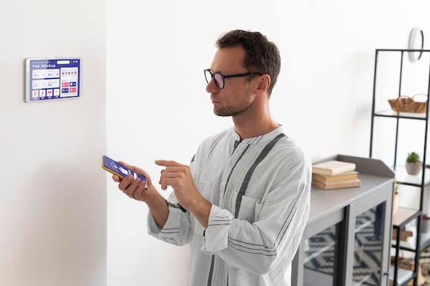 An electrician installing smart home technology, specifically a smart thermostat. The room is well-lit and modern.