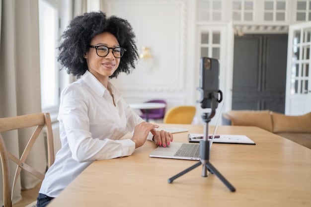 A person sitting at a desk making a video call, looking professional, in order to conduct an online job interview.