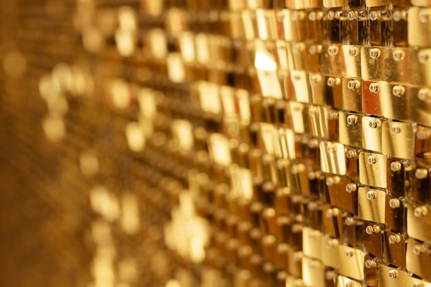 A close-up of several gold bars stacked neatly, reflecting light and emphasizing their purity. The background is blurred but suggests a secure vault environment.