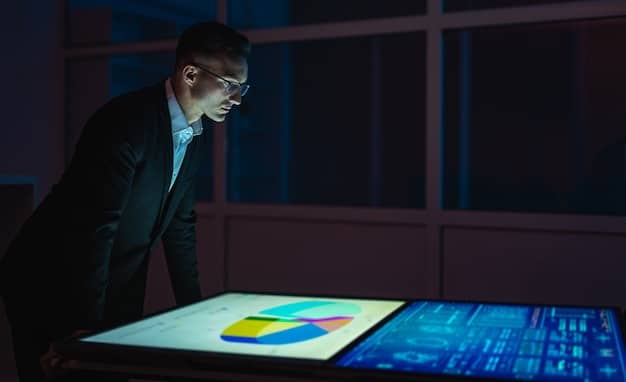 An investor reviewing an SRI fund prospectus, surrounded by documents and a laptop displaying ESG ratings and scores. The image should convey a sense of diligence and informed decision-making.