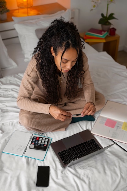 A person calculating expenses with a calculator and notebook, with the focus on financial planning and budgeting.