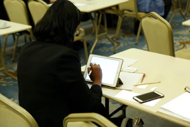 A student is anonymously filling out an online form on a laptop to report a bullying incident. The scene is set in a school library, with other students studying in the background.