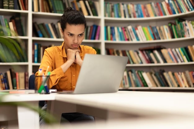 A focused first-generation college student studying in a library with books and a laptop, highlighting the dedication required to overcome academic challenges.