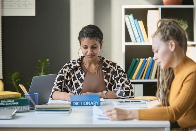 A school counselor is sitting at a table with a student, reviewing a college application. The counselor is pointing to a specific section of the application and offering advice about the student's essay.