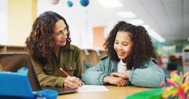 A teacher providing individualized feedback to a student during a classroom activity. The student is actively listening and taking notes.