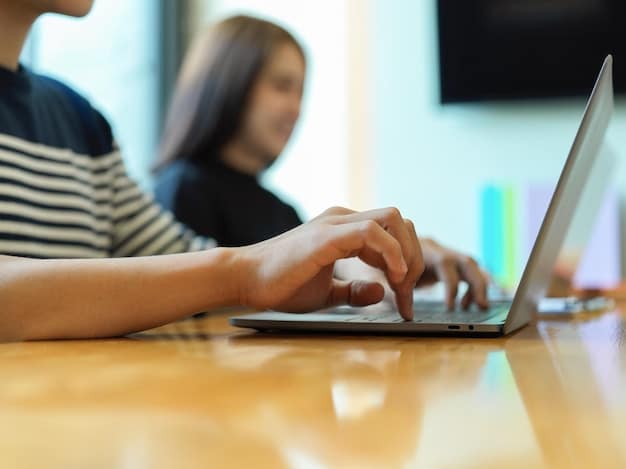 A close-up shot of a student's hands typing on a laptop, with a website displaying scholarship opportunities visible on the screen. The lighting is soft and focused on the keyboard.