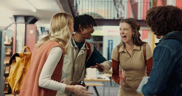 A group of students networking at a career fair, exchanging business cards and engaging in conversation. The atmosphere is lively and professional, with banners of different organizations visible in the background.