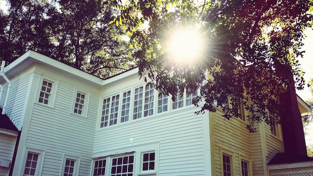 A picturesque suburban house with a bright sun shining on it, symbolizing the relief that homeowners feel when receiving property tax assistance.